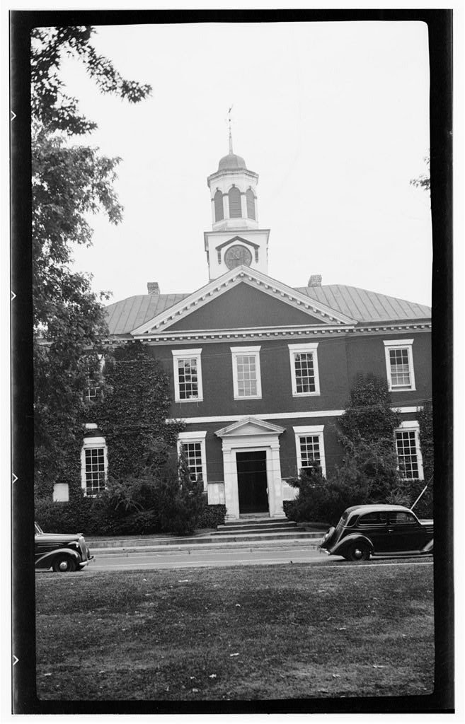 Brick Chowan County Courthouse in Edenton with a white cupola and clock, old cars parked in front